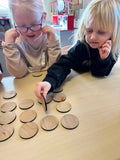 Two preschoolers exploring the Basic Shapes Matching Game at a table, focusing on identifying and matching wooden shape tiles. Ideal for Pre-K and daycare to support cognitive growth, fine motor skills, and shape recognition.