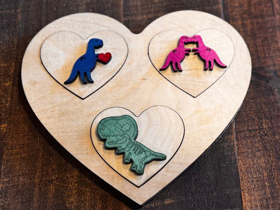 Heart-shaped Peekaboo Dinosaur Valentine Puzzle with vibrant wooden pieces featuring letters V, K, and X for Valentine, Kissing, and X-ray. Perfect for preschool, Pre-K, and homeschool learning