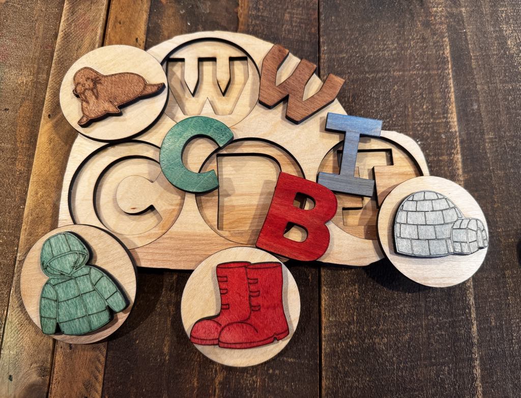 Wooden Igloo Peekaboo Puzzle in progress, with letter pieces removed to reveal matching symbols, encouraging fine motor skills and early literacy development.