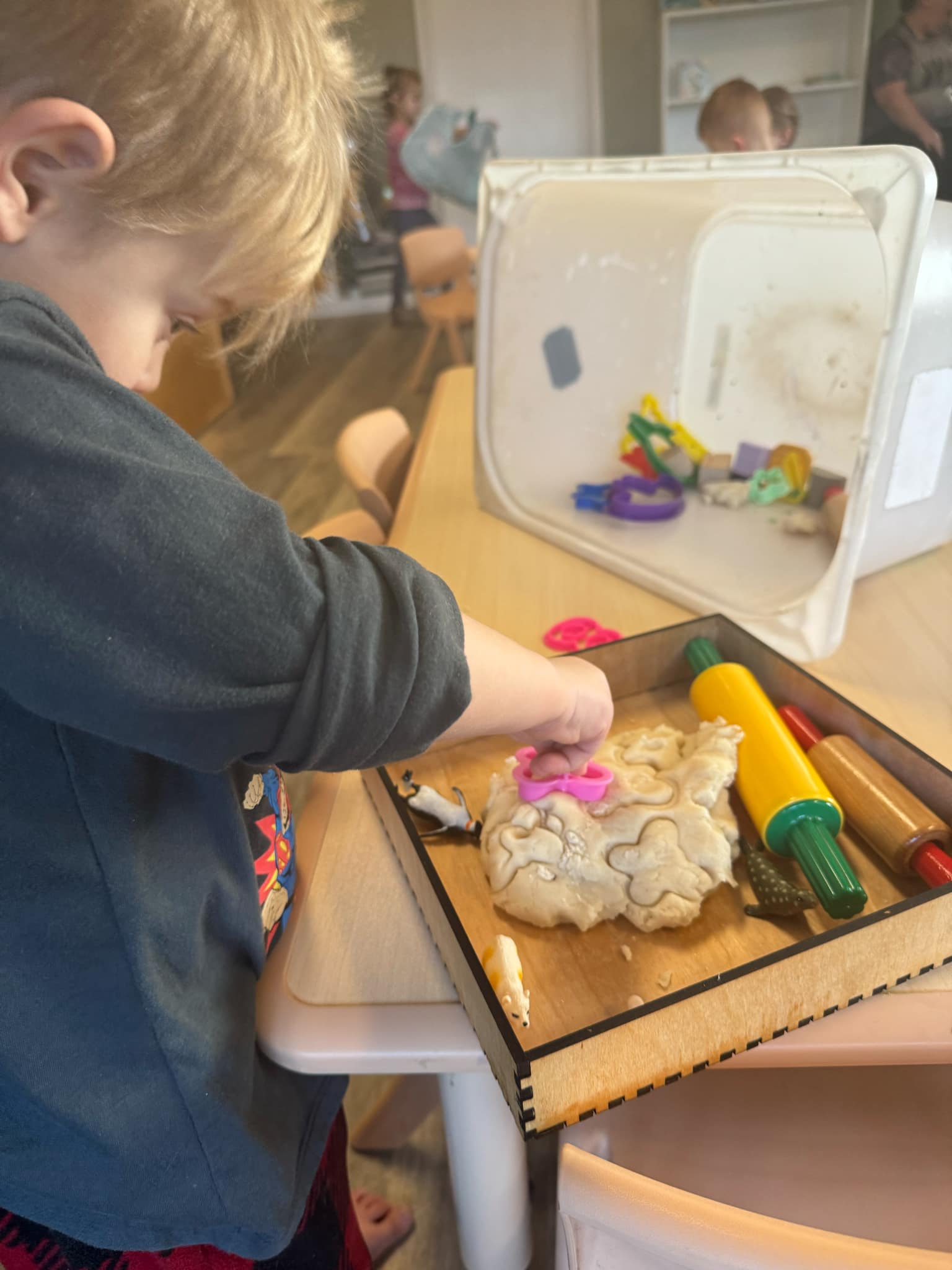 Child engaging with tactile play using dough and tools in the PreKwithMe sensory tray, enhancing fine motor skills and hand-eye coordination for preschool learning