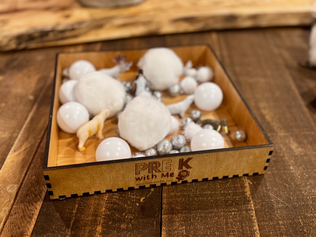 Sensory bin filled with snowy-themed items, showcasing its use for critical thinking, problem-solving, and imaginative play in young learners.